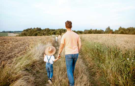 Father and son walking in field