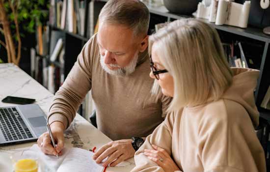 Man and woman writing in notebook